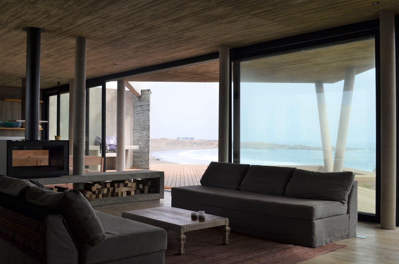 Living de Casa Agua Dulce con cielo de madera termotratada y vista al mar