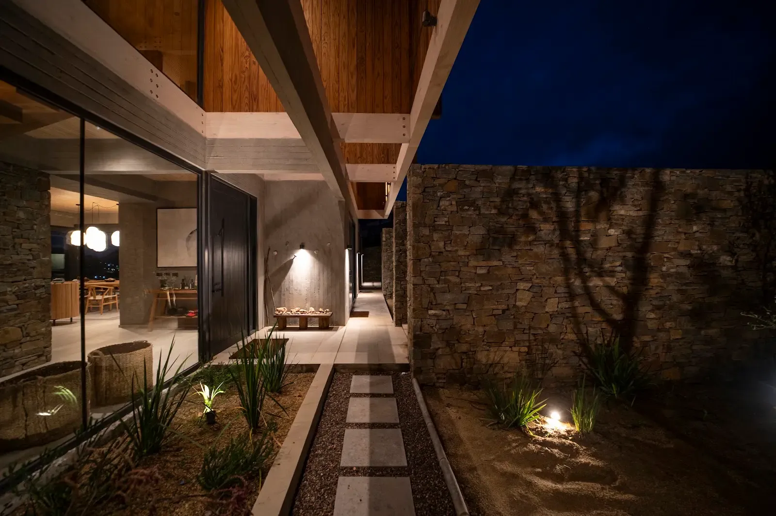 Patio de Casa Fundo Zapallar al anochecer, con aleros de madera