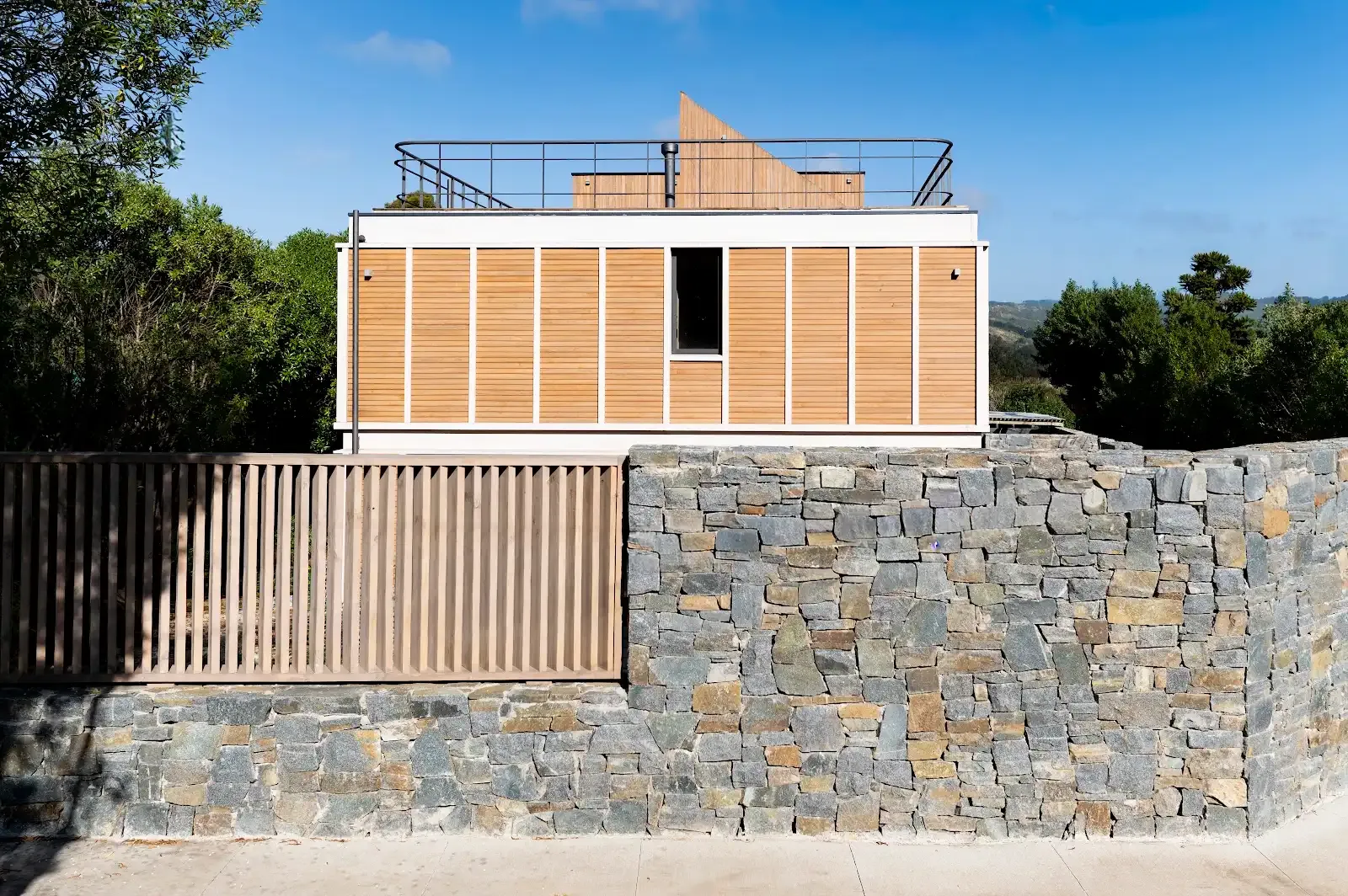 Fachada de Conjunto Cachagua II con revestimiento TW-02A y muro de piedra